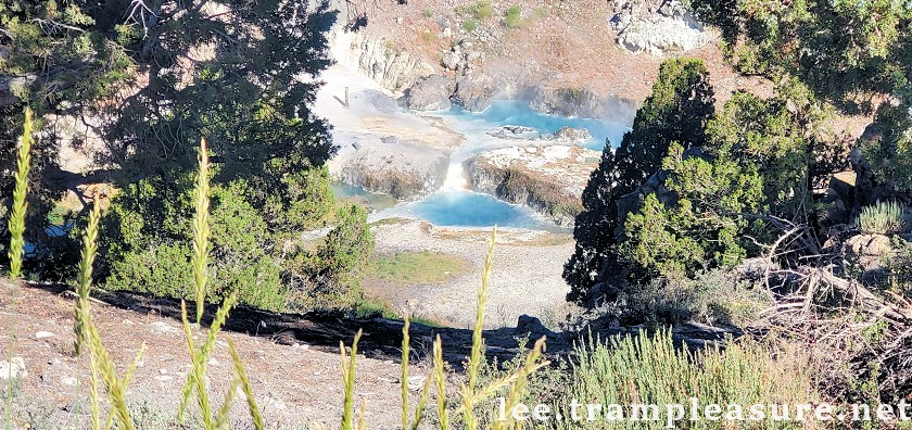 photo showing bright blue/teal pool with steaming water flowing into the stream