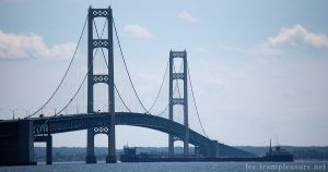 photo of the Mackinaw bridge with a large ship passing under it