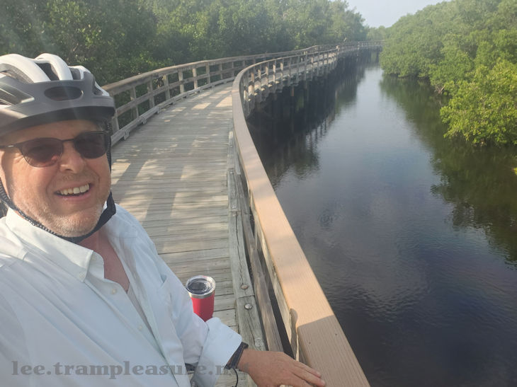 photo of a cyclist on a boardwalk over a lagoon