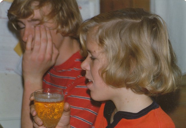 Photo showing Lee with a glass of sparkling cider with Calvin behind him