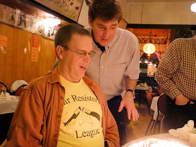 Photo showing Lee smiling in front of a birthday cake with Calvin behind him